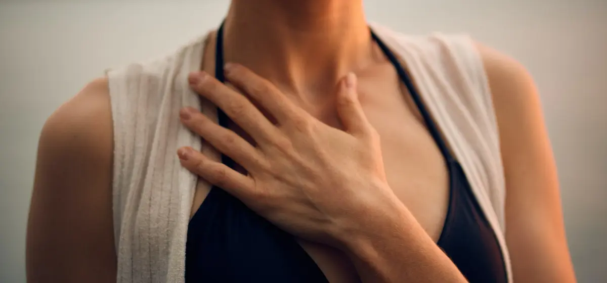 Frau hält Hand vor Oberkörper